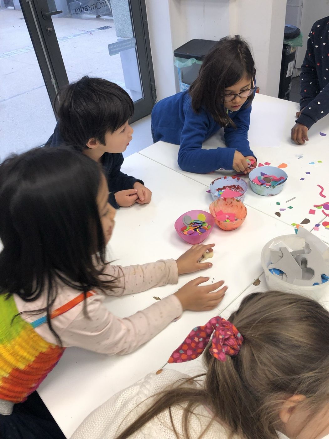 Des enfants autour d'une table de collage