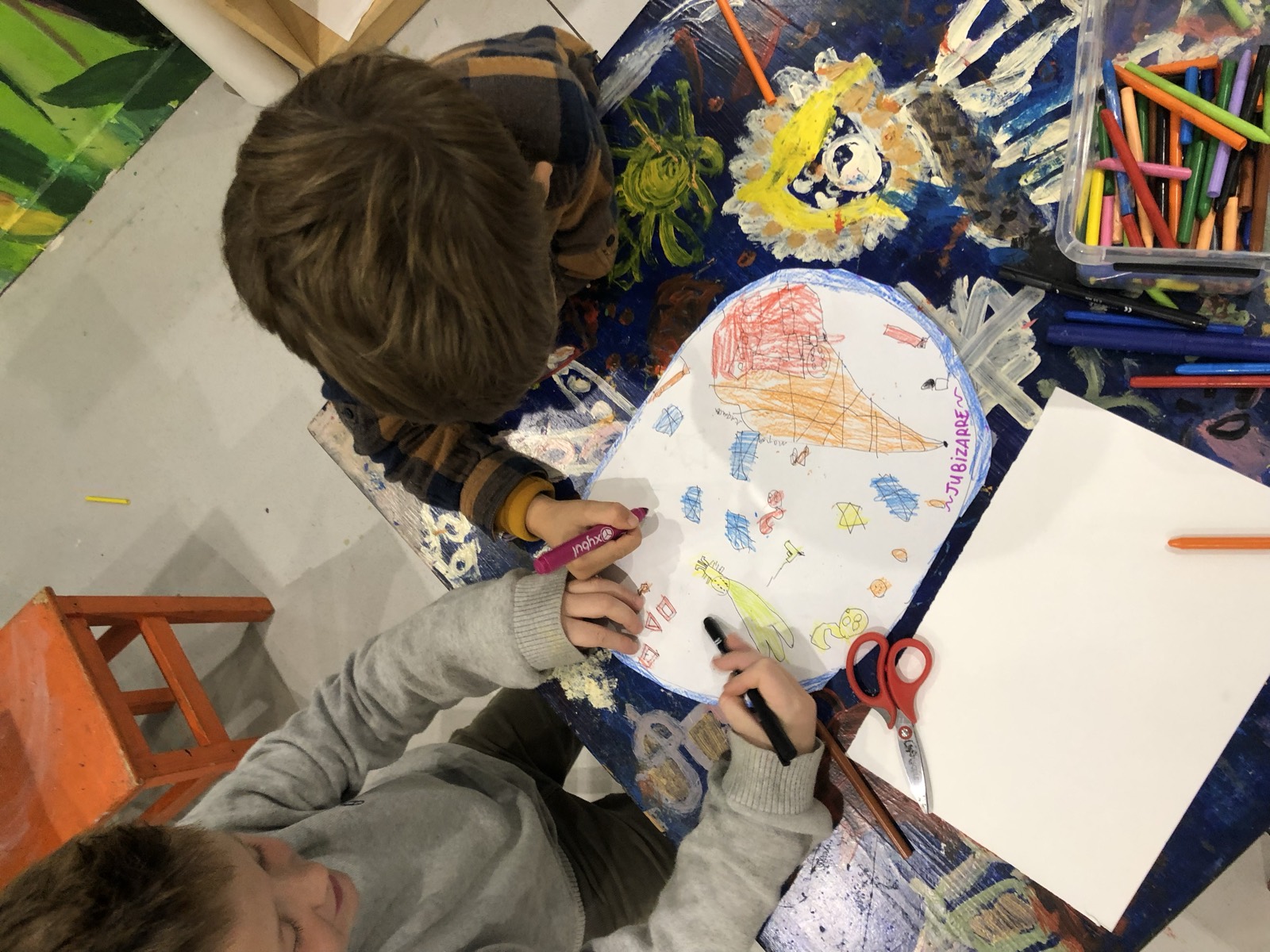 Des mains d'enfants décorent une assiette en papier