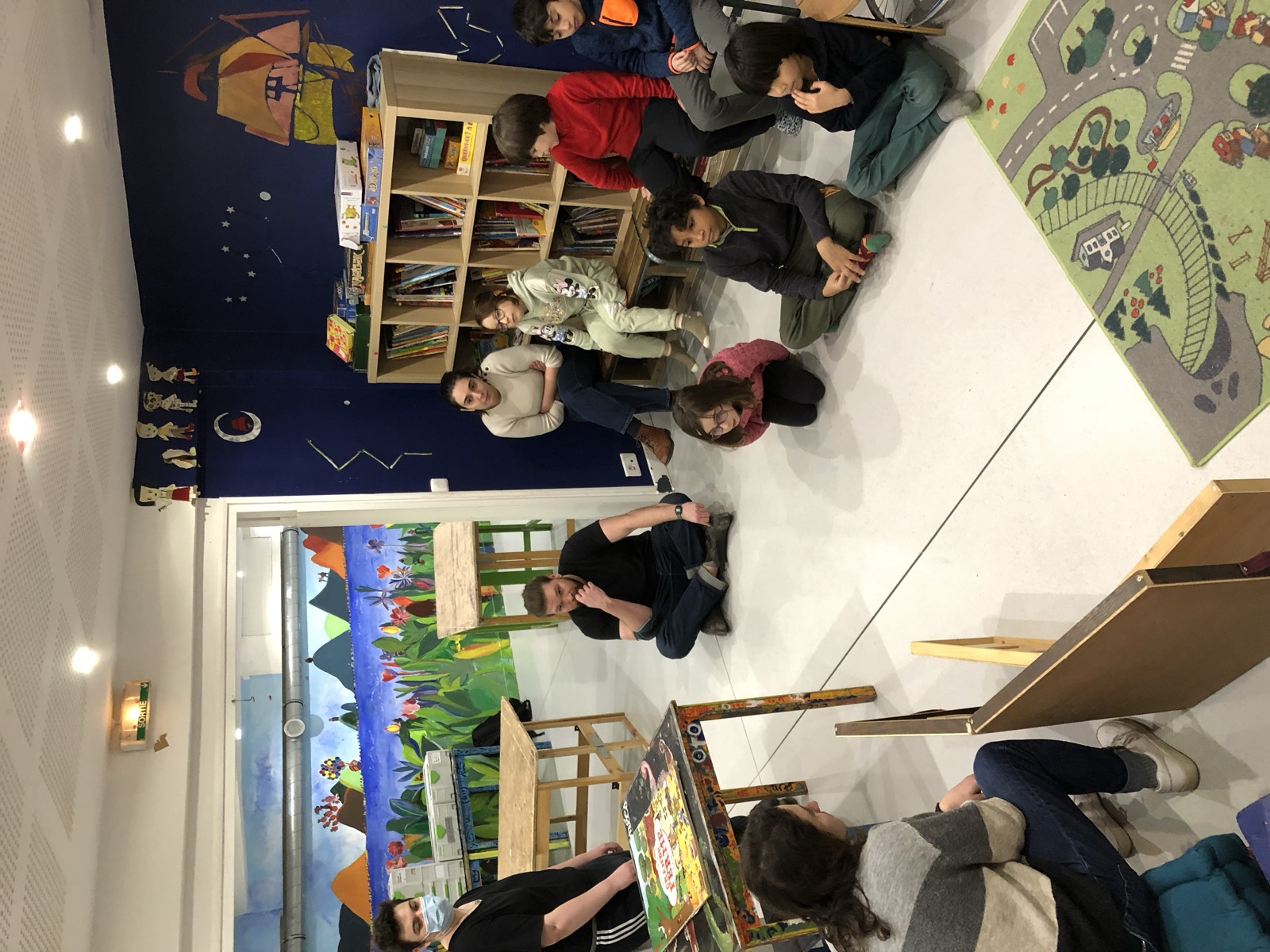 Un groupe d'enfants assis au sol avant le début de l'atelier