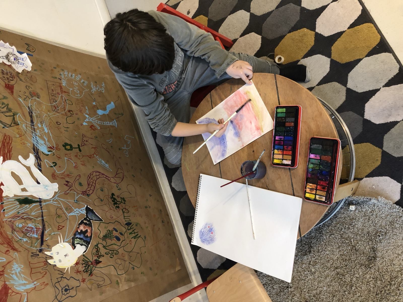 Un enfant peint devant un grand panneau